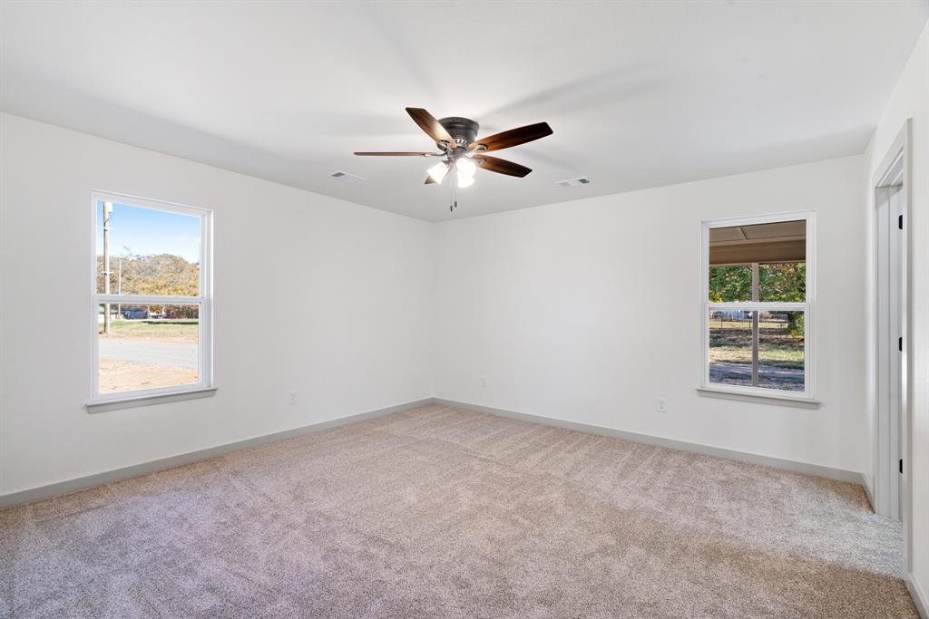 728 County Road Powderly, TX 75473 - Photo 11 of 24 an empty room with a window and a fan