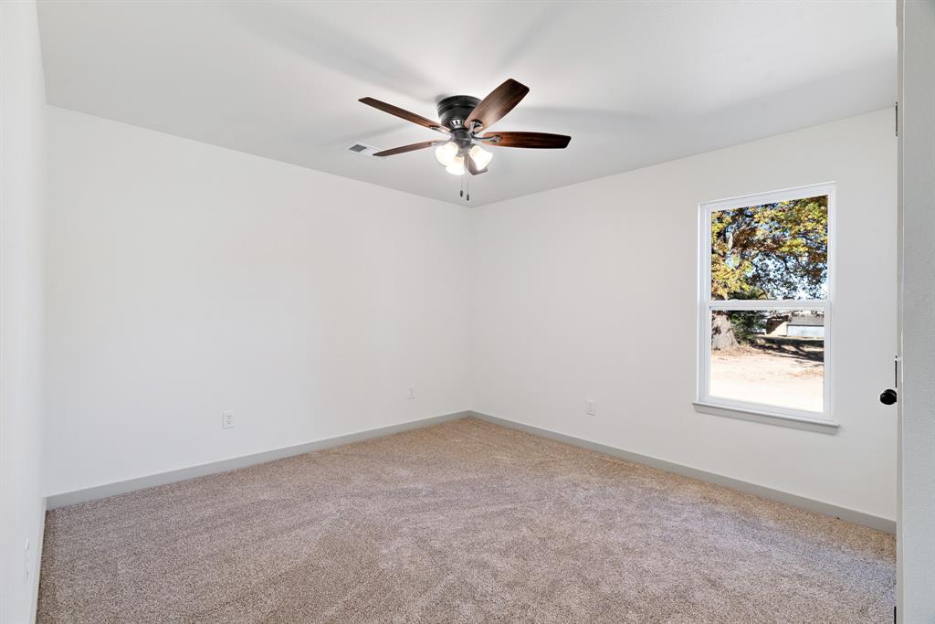 728 County Road Powderly, TX 75473 - Photo 13 of 19 an empty room with a window and a fan