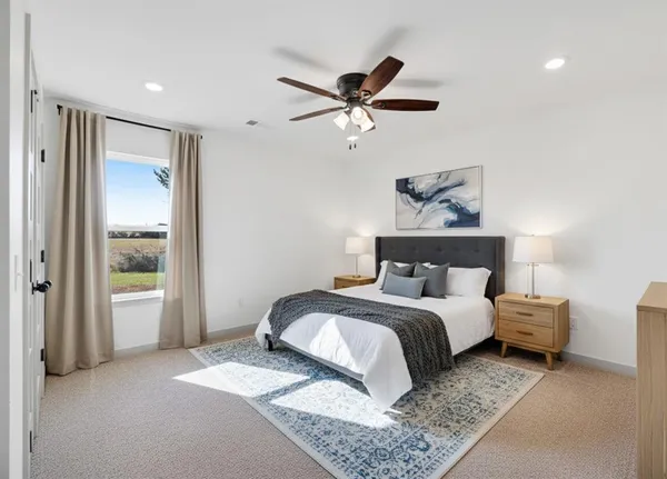 a spacious bedroom with a bed and a chandelier