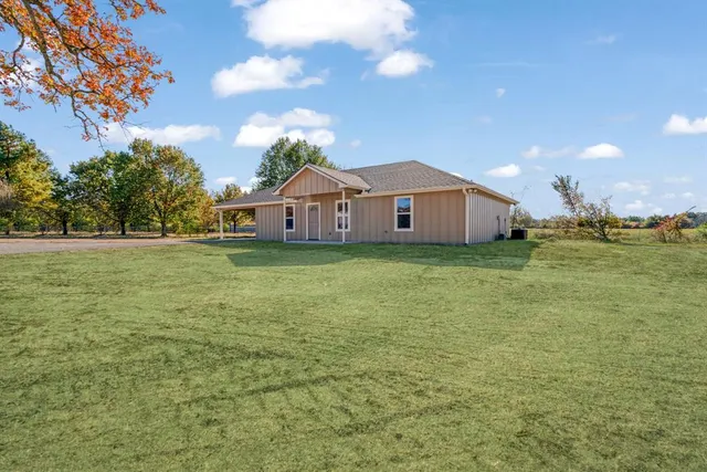 a view of a house with a yard and sitting area