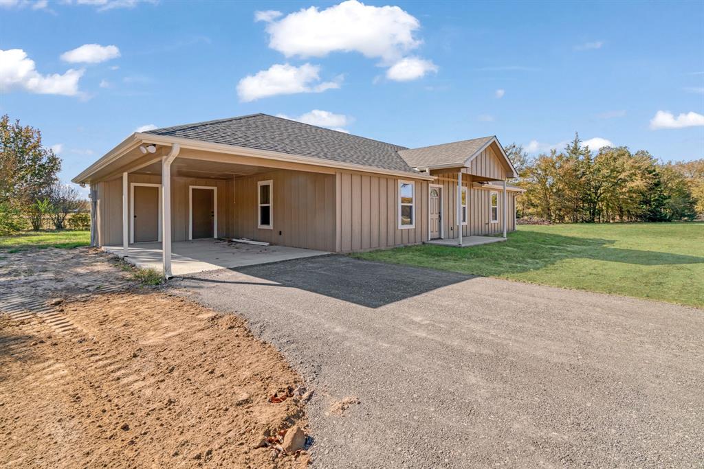 728 County Road Powderly, TX 75473 - Photo 4 of 24 a front view of a house with a yard and garage