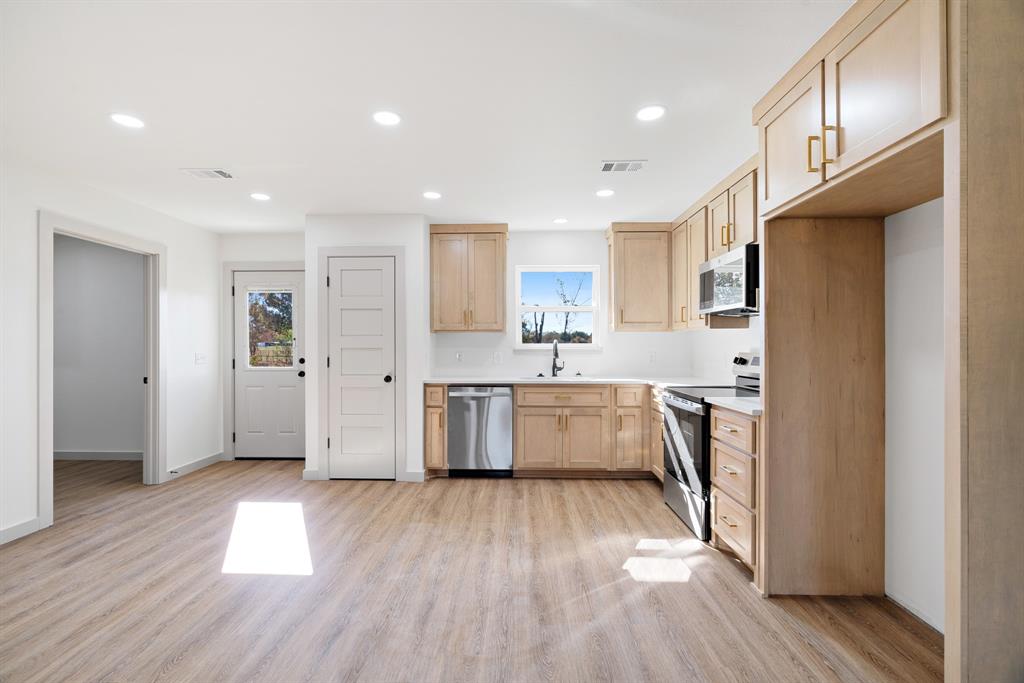 728 County Road Powderly, TX 75473 - Photo 6 of 24 a large kitchen with a lot of counter space wooden floor and stainless steel appliances