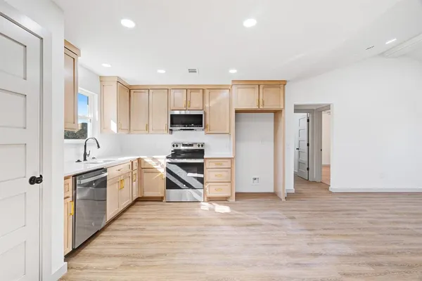 a kitchen with white cabinets and stainless steel appliances