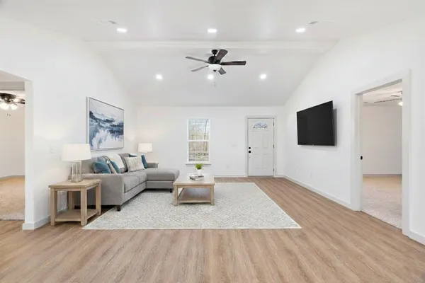 a living room with furniture wooden floor and a flat screen tv