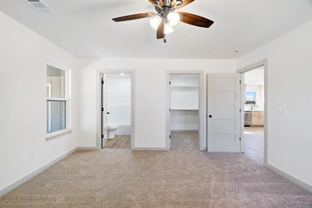 an empty room with closet and windows