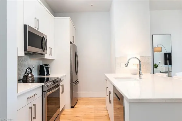 a kitchen with stainless steel appliances granite countertop a sink and a microwave