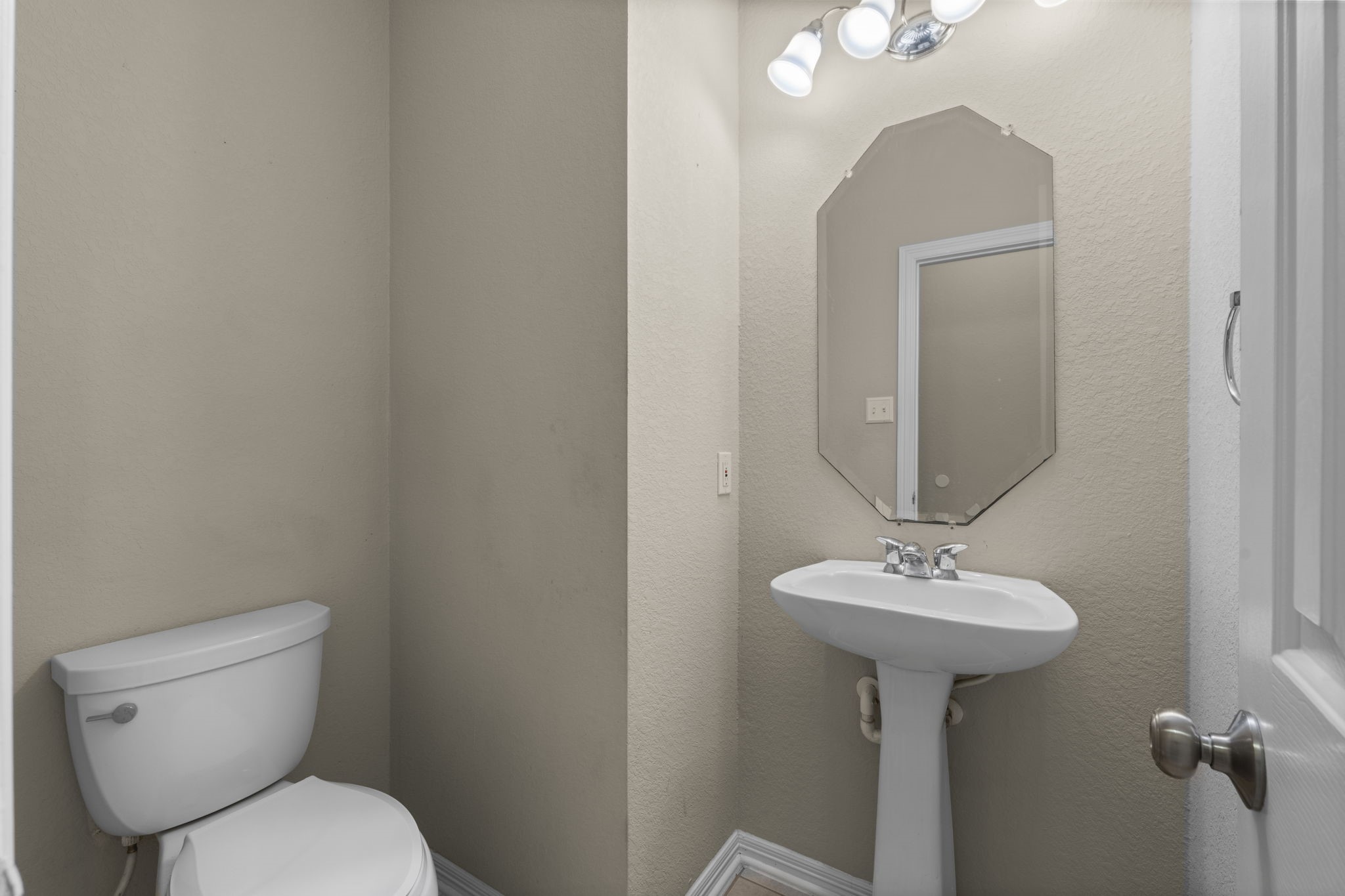 19327 Dickson Park Drive Spring, TX 77373 - Photo 21 of 43 The downstairs guest half bath features tile flooring, pedestal sink, toilet, and beveled octagon mirror.