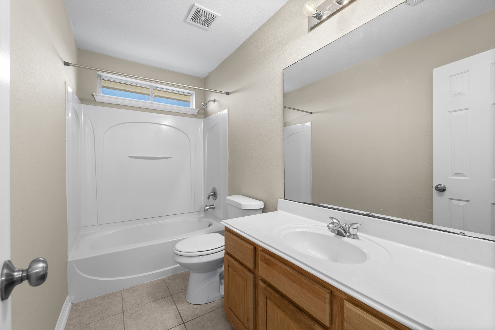 19327 Dickson Park Drive Spring, TX 77373 - Photo 33 of 43 2nd full bathroom for the upstairs bedrooms includes single sink with extended vanity counter top, tile flooring, hall linen closet, toilet, and a shower/tub combo with clerestory window for natural light and privacy.