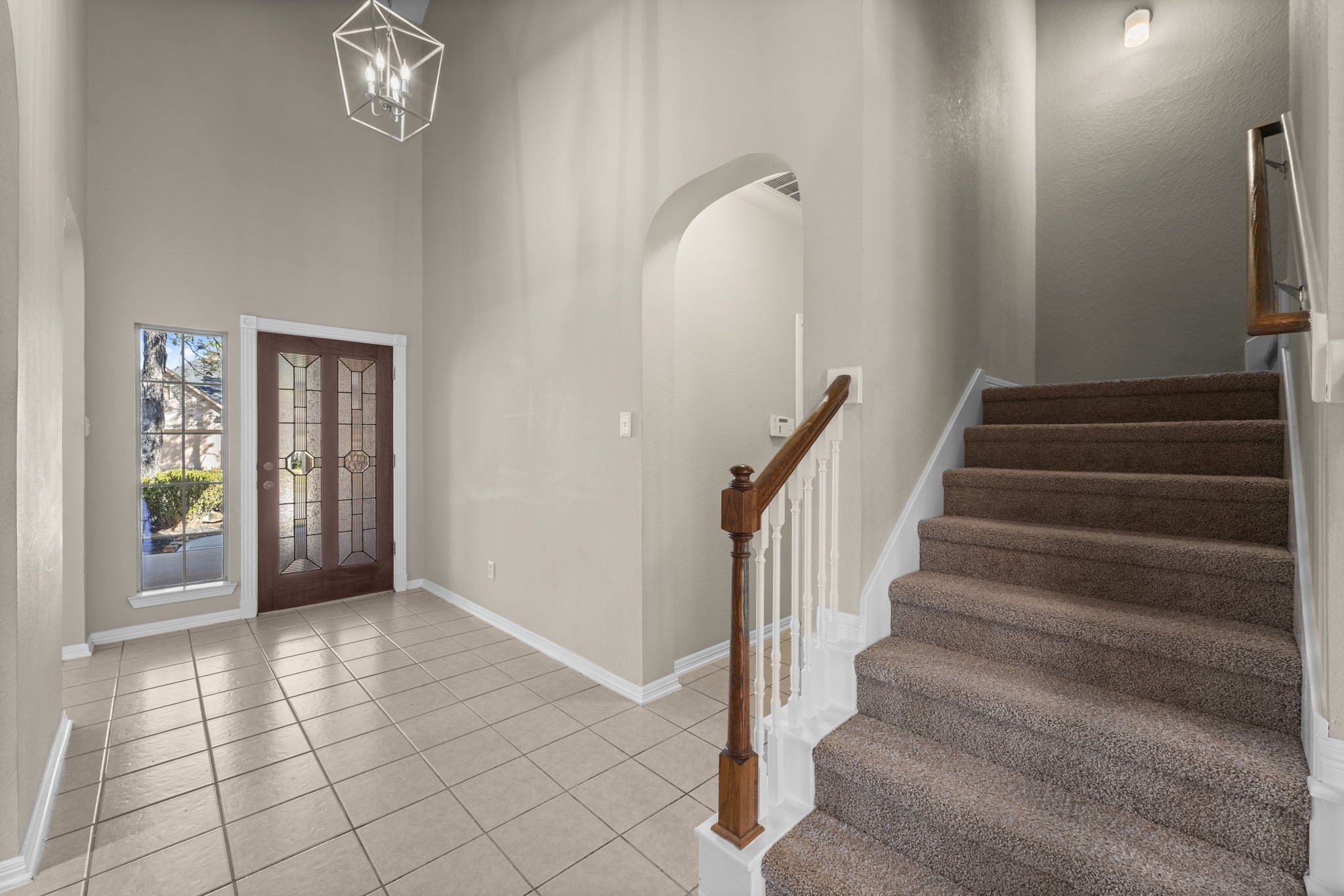 19327 Dickson Park Drive Spring, TX 77373 - Photo 5 of 43 Another view of the foyer highlights the elegant leaded glass and wood front door, flanked by a large window that fills the space with natural light. This gracious entry is both beautiful and functional, offering ample space for an entry table or bench. The grand staircase leads to three bedrooms, a bath, a huge Game room, and a Media area.