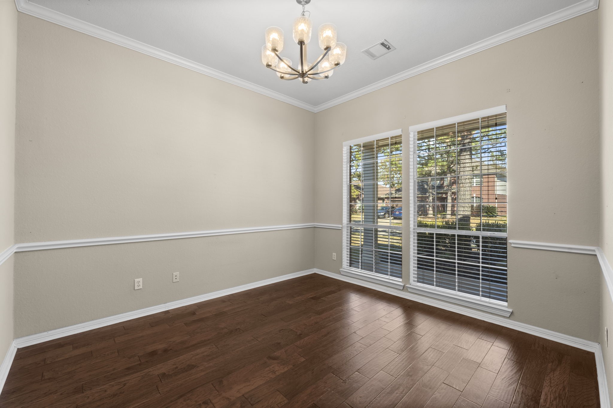 19327 Dickson Park Drive Spring, TX 77373 - Photo 7 of 43 Gather your guests and celebrate in this stunning Formal Dining Room, designed for both grandeur and comfort. With plenty of space for a large dining table and full furniture suite, this room is perfect for any special occasion. It features wood laminate flooring, elegant chair rail, crown molding, and a designer chandelier.
