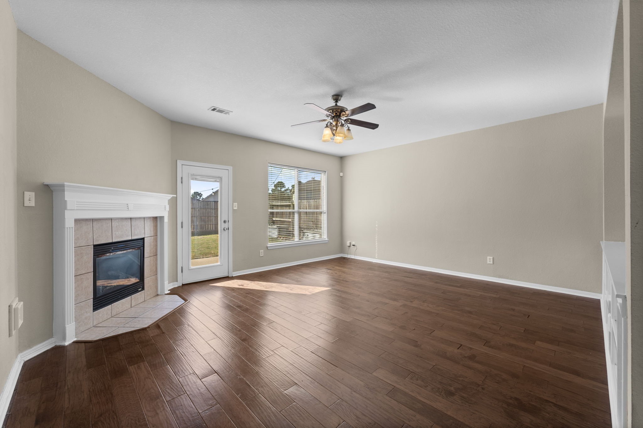 19327 Dickson Park Drive Spring, TX 77373 - Photo 9 of 43 This beautifully designed Family Room blends style and function, featuring wood laminate flooring and a cozy gas log fireplace. A lighted ceiling fan adds both comfort and charm. Conveniently located just off the kitchen, this open-concept space makes it easy to stay connected while entertaining or enjoying everyday moments.