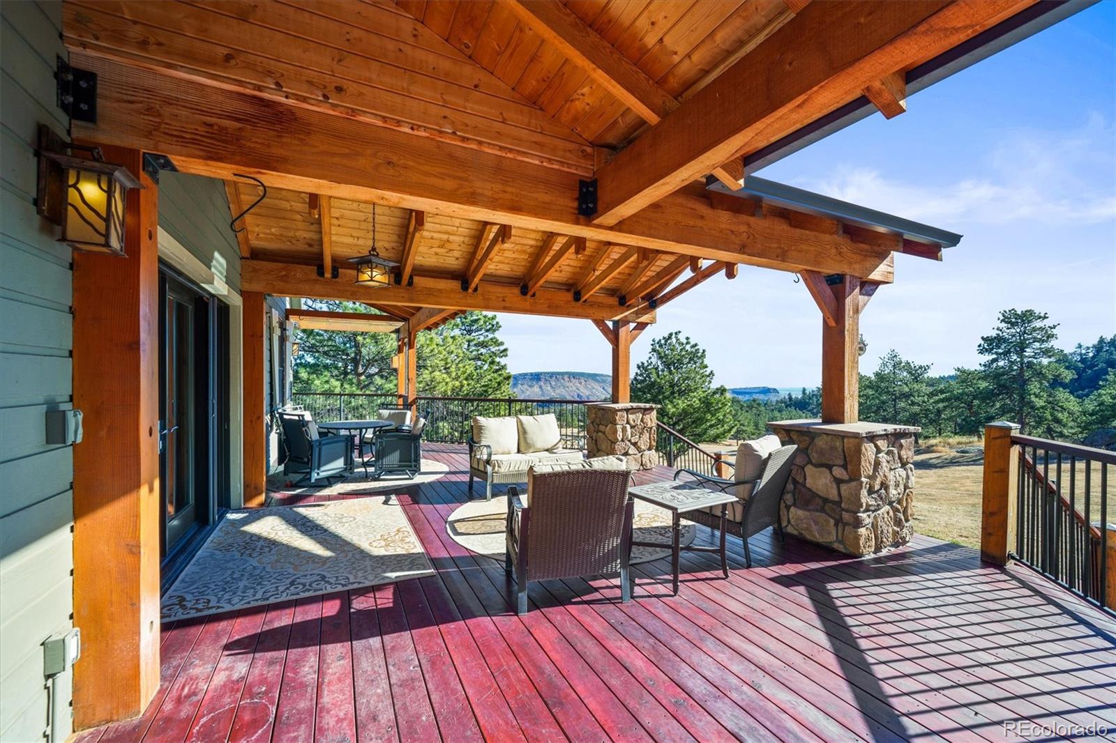 3665 Colard Lane Lyons, CO 80540 - Photo 2 of 50 a view of a patio with table and chairs potted plants with wooden floor and floor to ceiling window