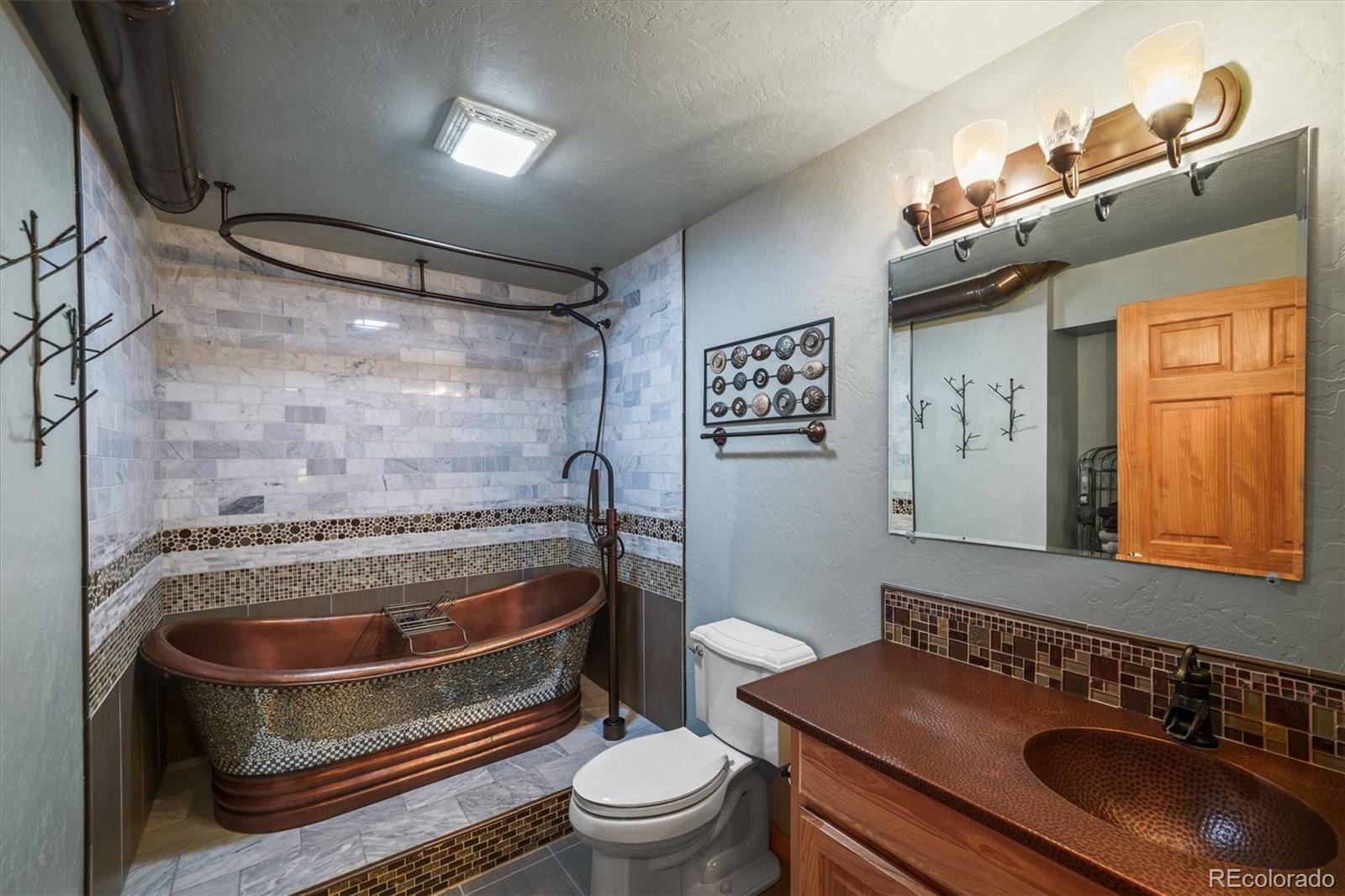 3665 Colard Lane Lyons, CO 80540 - Photo 31 of 50 a bathroom with a sink a toilet and a mirror