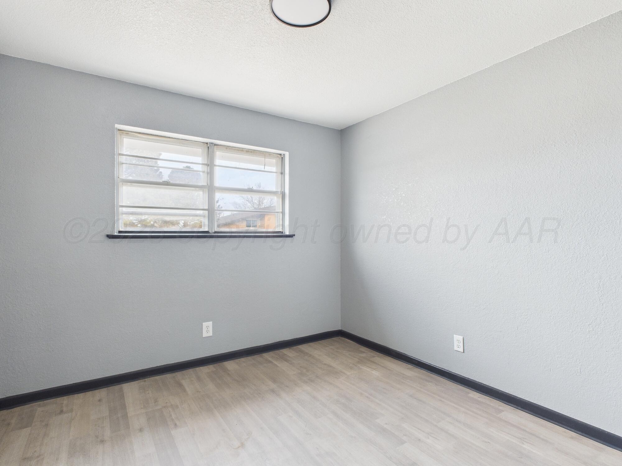 1002 Northeast 4th Street Dumas, TX 79029 - Photo 4 of 8 an empty room with windows