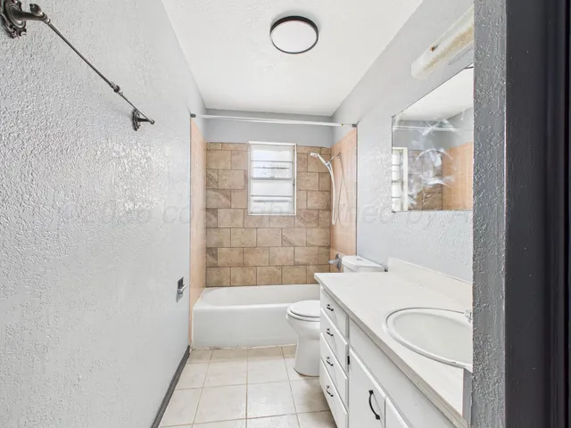 a bathroom with a granite countertop sink a toilet and bathtub