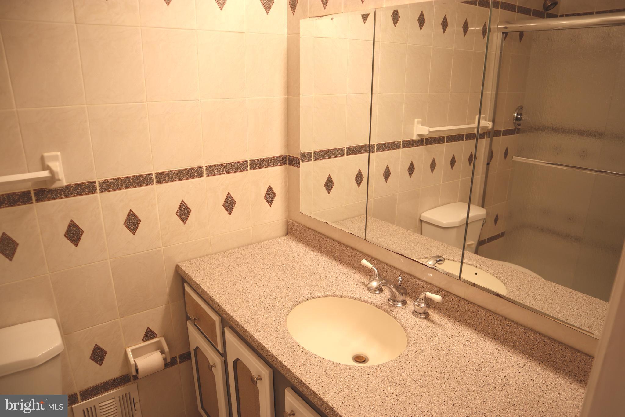 8501 Fairburn Drive Springfield, VA 22152 - Photo 13 of 30 a bathroom with a sink and mirror with toilet