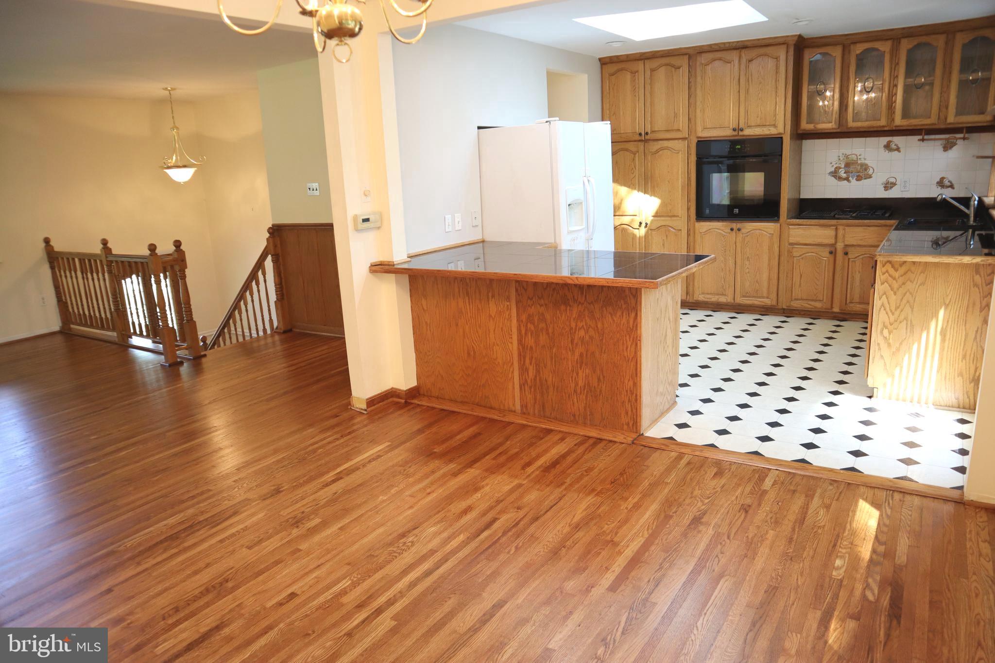8501 Fairburn Drive Springfield, VA 22152 - Photo 3 of 30 a kitchen with granite countertop a refrigerator and a stove top oven