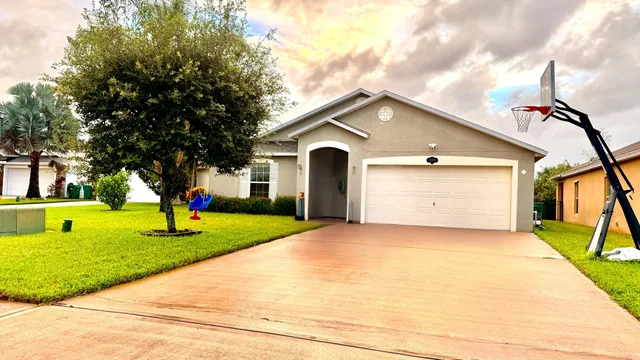 a front view of a house with a yard and trees