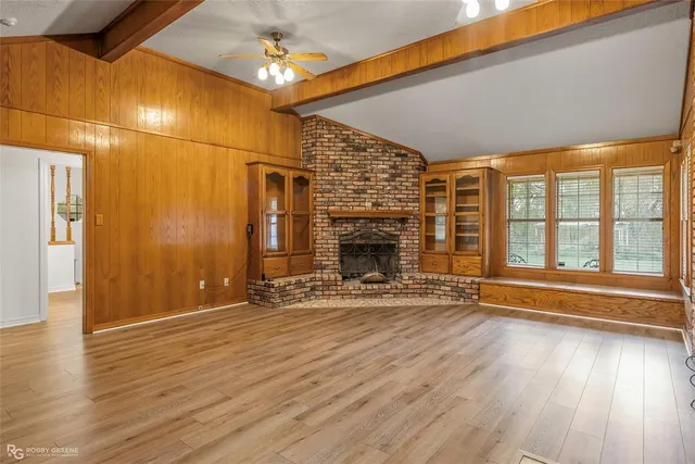 a view of empty room with wooden floor and fireplace