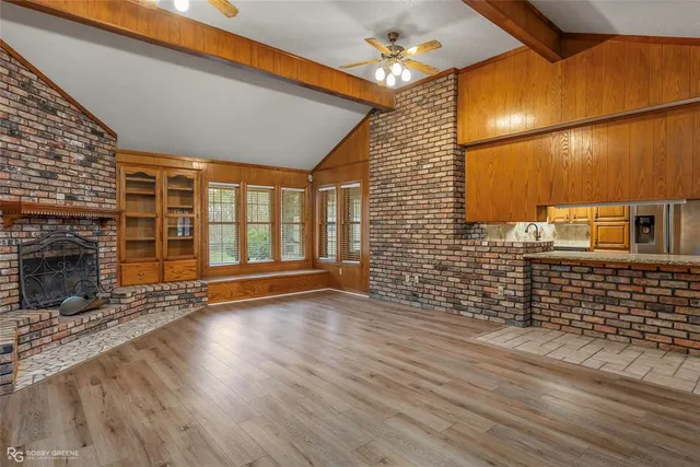 an empty room with wooden floor and fireplace