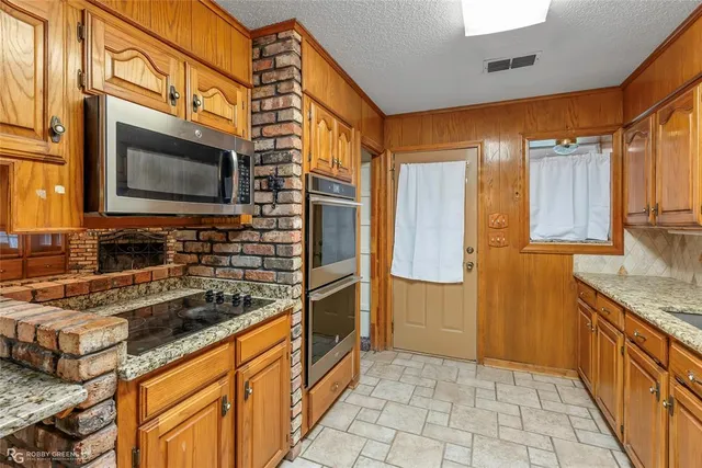a kitchen with stainless steel appliances granite countertop a sink and a stove