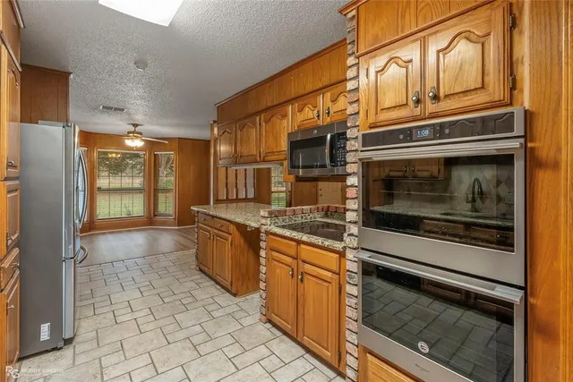 a kitchen with stainless steel appliances granite countertop a stove and a refrigerator