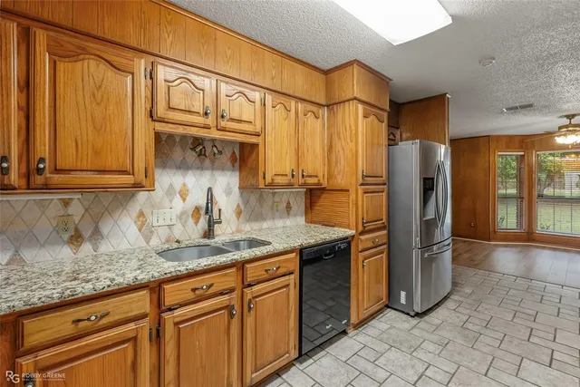 a kitchen with stainless steel appliances granite countertop a refrigerator and a sink