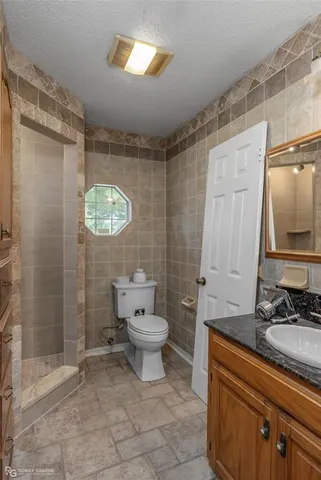 a bathroom with a toilet sink shower and mirror