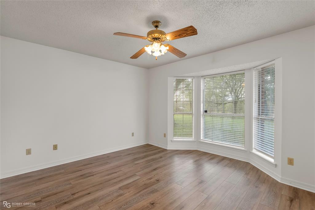 5425 Modica Lott Road Bossier City, LA 71111 - Photo 27 of 31 an empty room with wooden floor fan and windows