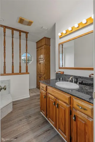 a bathroom with a granite countertop double vanity sink and mirror