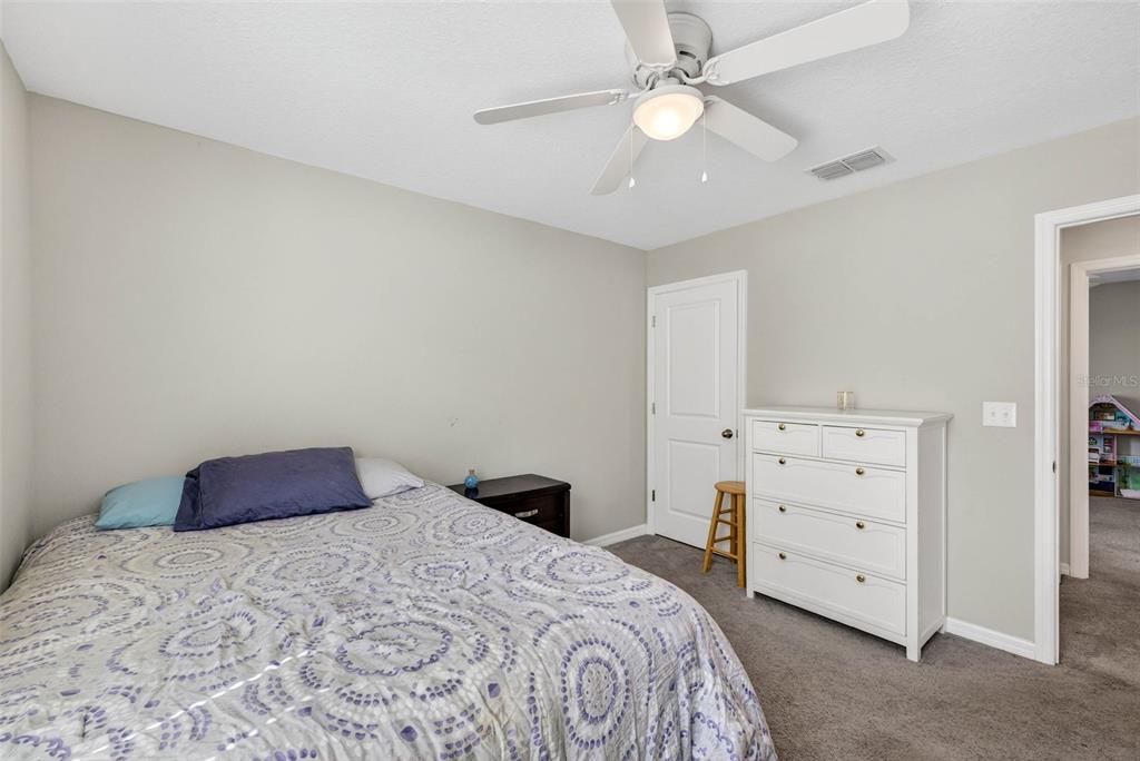 9616 Lemon Drop Loop Sun City Center, FL 33573 - Photo 38 of 53 a bedroom with a bed and a ceiling fan