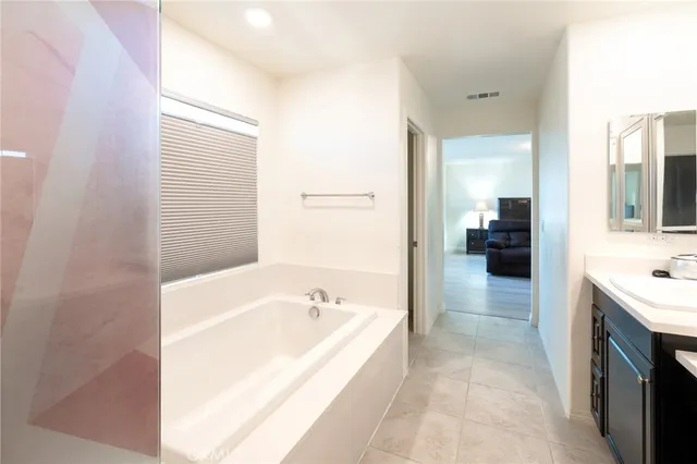 a spacious bathroom with a bathtub sink and mirror