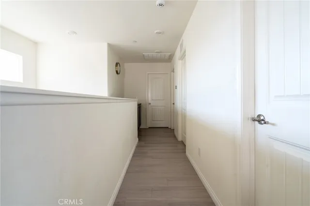 a view of a hallway with wooden floor and closet