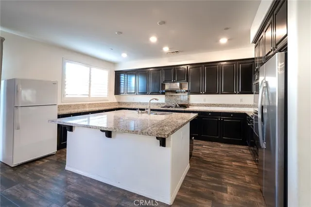 a kitchen with a refrigerator sink and cabinets