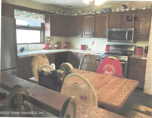 a kitchen with stainless steel appliances granite countertop a refrigerator a sink dishwasher a stove and white countertops with cabinets