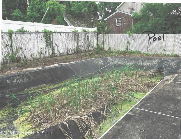 a backyard of a house with lots of green space and wooden fence