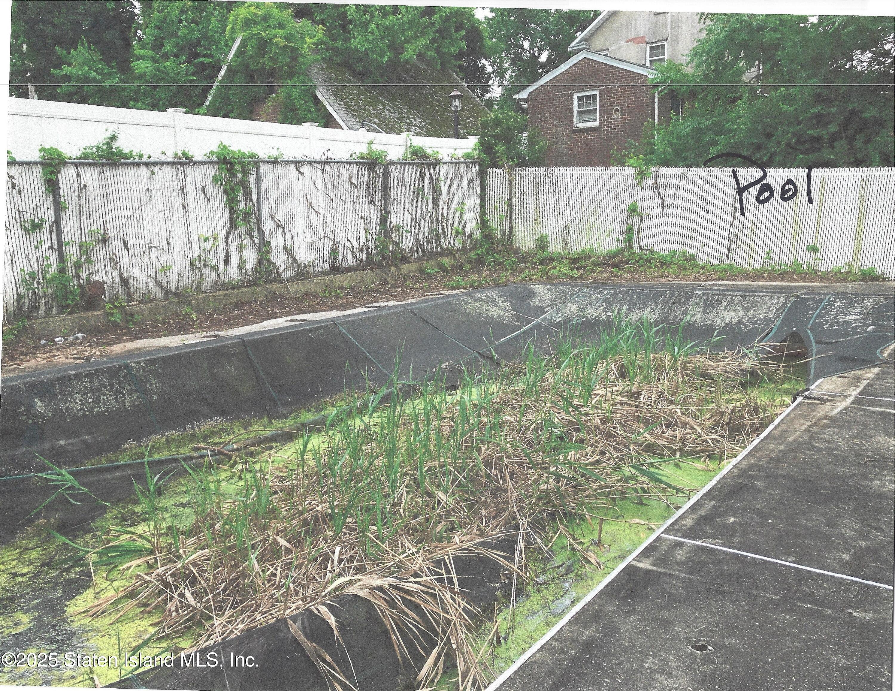 610 Woodrow Road Staten Island, NY 10312 - Photo 7 of 9 a backyard of a house with lots of green space and wooden fence
