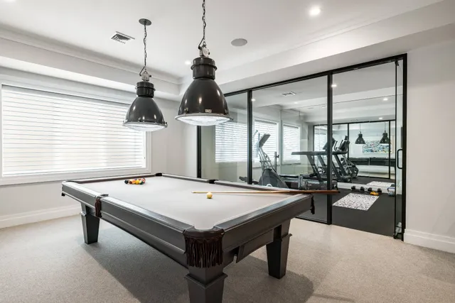 a room with pool table and windows