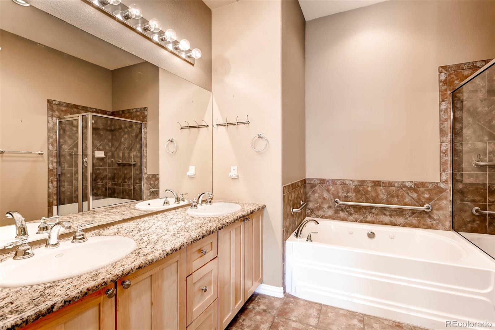 8300 Fairmount Drive, Unit N101 Denver, CO 80247 - Photo 18 of 27 a bathroom with a granite countertop tub sink and mirror