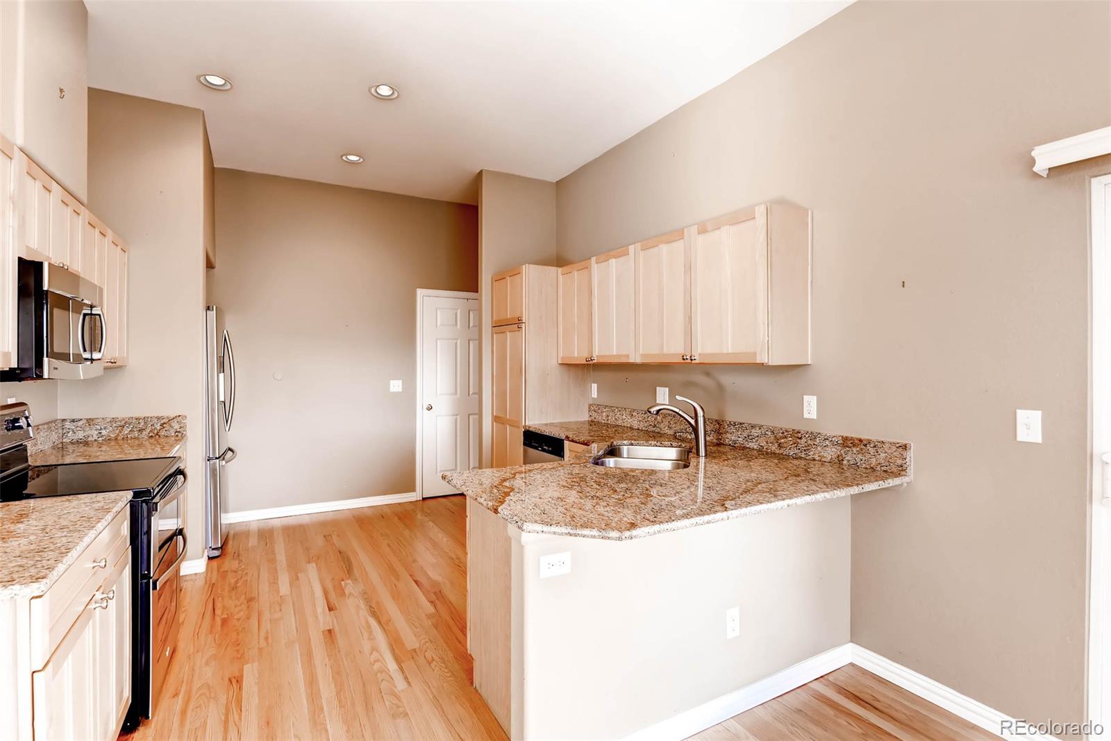 8300 Fairmount Drive, Unit N101 Denver, CO 80247 - Photo 9 of 27 a kitchen with a sink a stove and cabinets