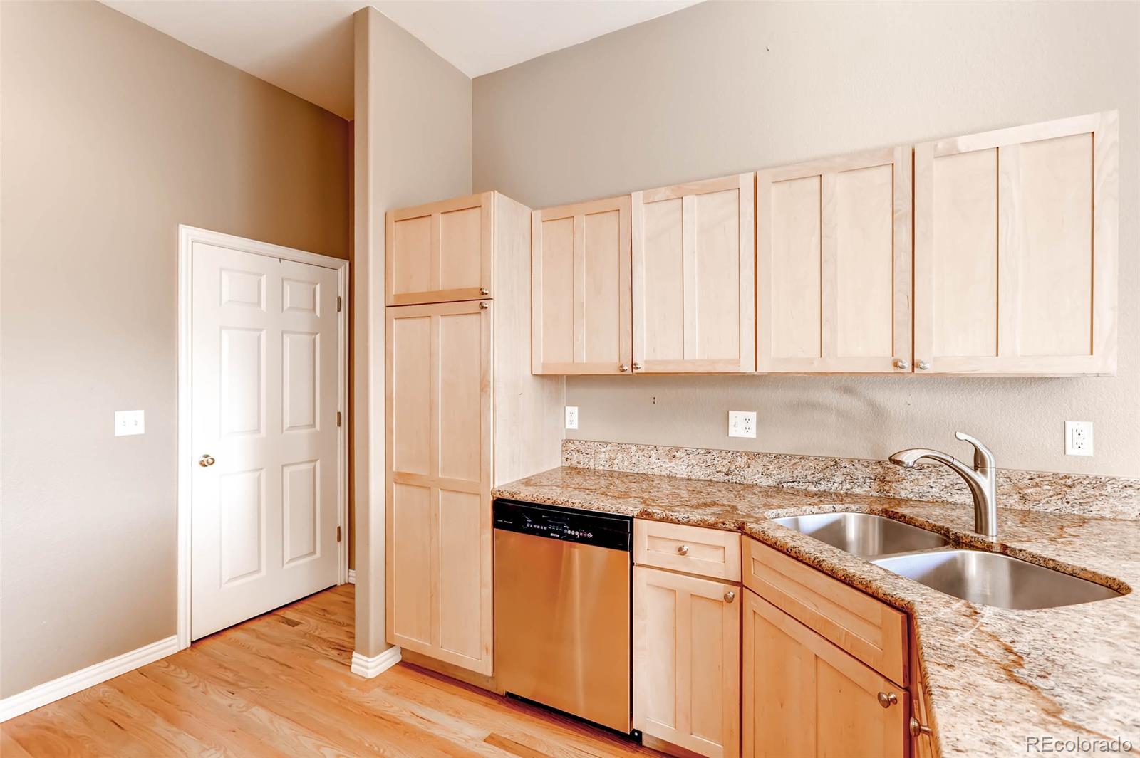 8300 Fairmount Drive, Unit N101 Denver, CO 80247 - Photo 10 of 27 a kitchen with granite countertop white cabinets white appliances and sink