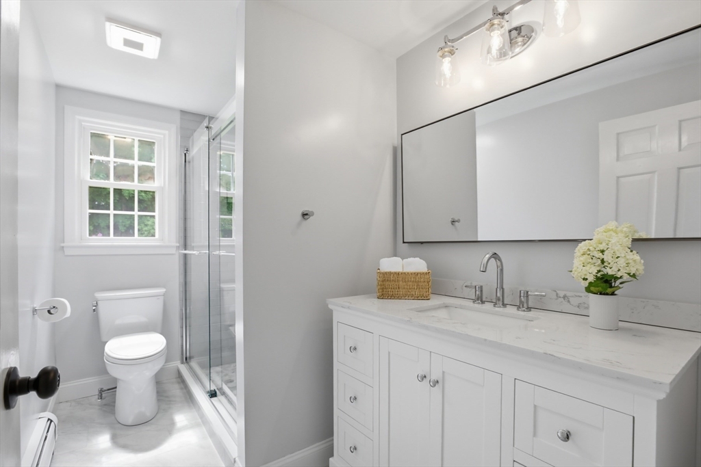 94 Johnson Road Winchester, MA 01890 - Photo 13 of 40 a bathroom with a granite countertop sink a toilet and mirror