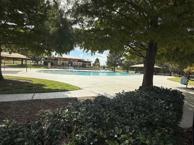 a view of a lake with a yard and large trees