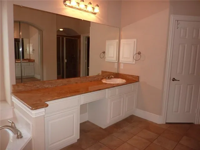 a bathroom with a granite countertop sink and a mirror