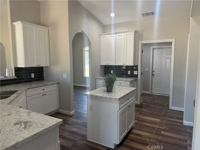 a kitchen with kitchen island a sink stove and refrigerator