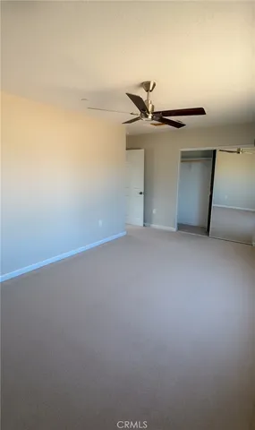 an empty room with a window and a fan
