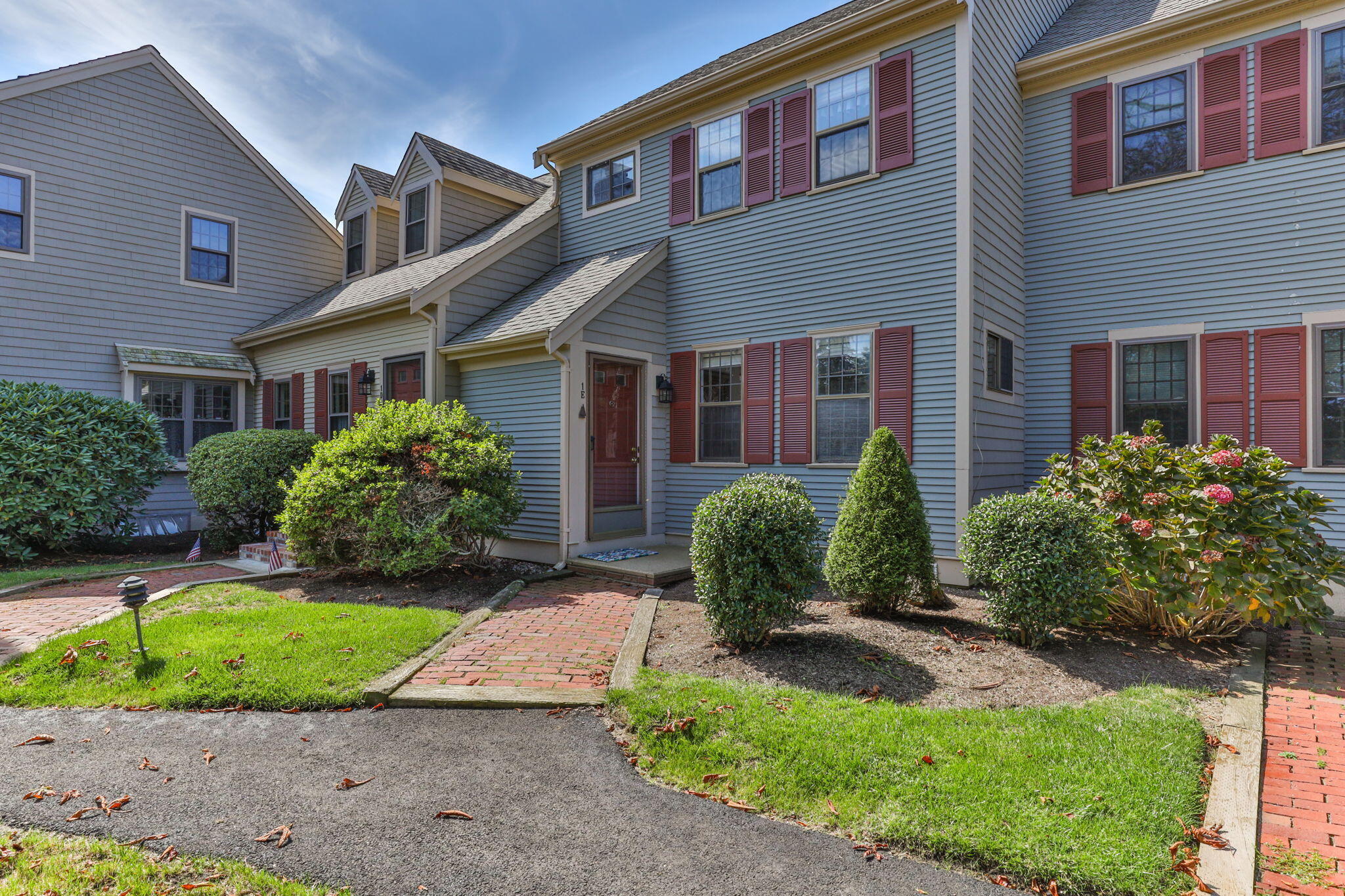 a front view of a house with a yard and potted plants