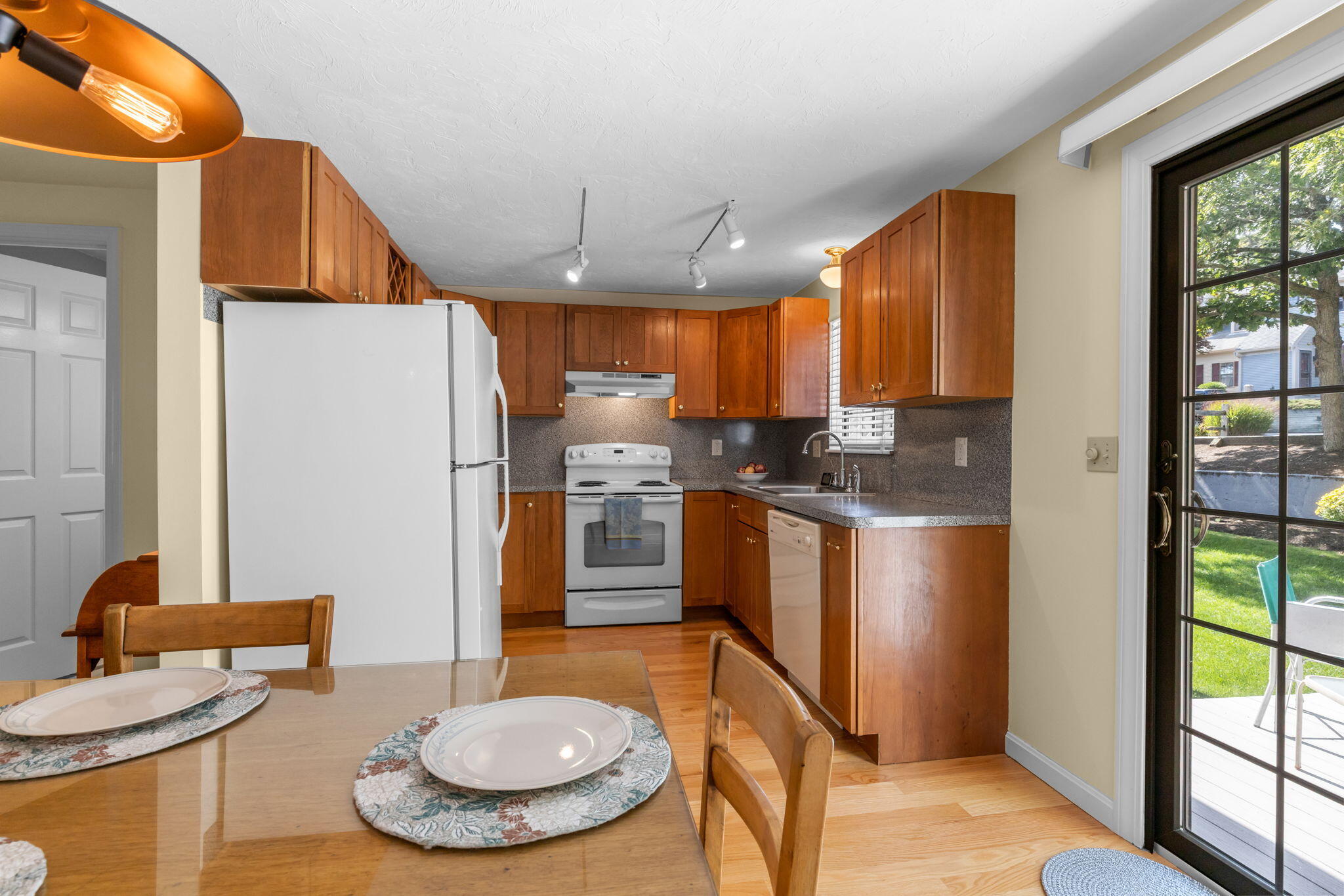 45 West Road, Unit 1E Orleans, MA 02653 - Photo 12 of 37 a kitchen with stainless steel appliances granite countertop a refrigerator a sink a stove and a dining table with wooden floor