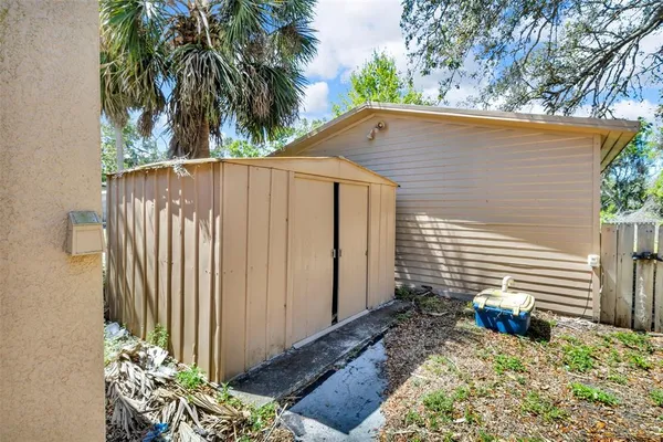 a view of a house with a yard covered with snow and trees