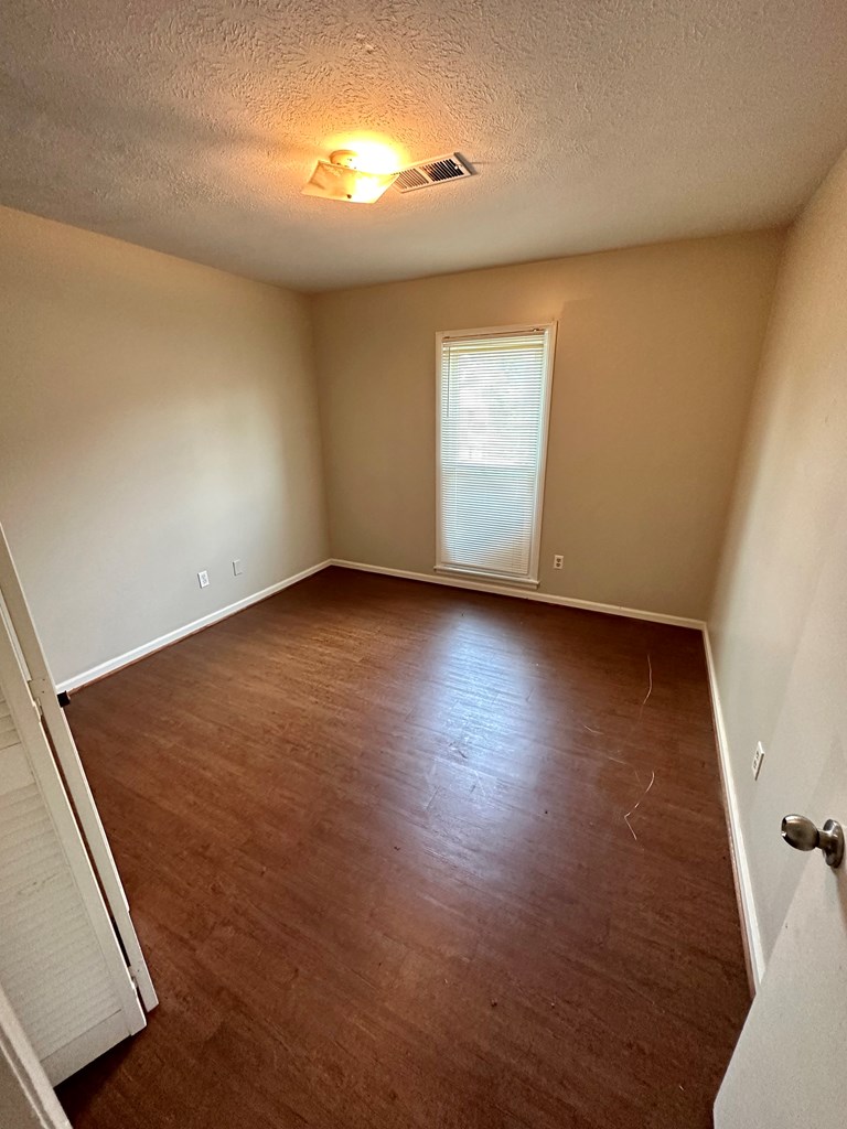116 Whippoorwill Lane Columbus, GA 31906 - Photo 11 of 13 an empty room with wooden floor and windows